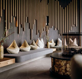 Rieser- Lobby/Loungebereich Akustikpaneele, Sitzbank in grau, Zierkissen in goldenem Velours